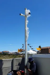 Technician installing CCTV cameras on a security pole in Cape Town